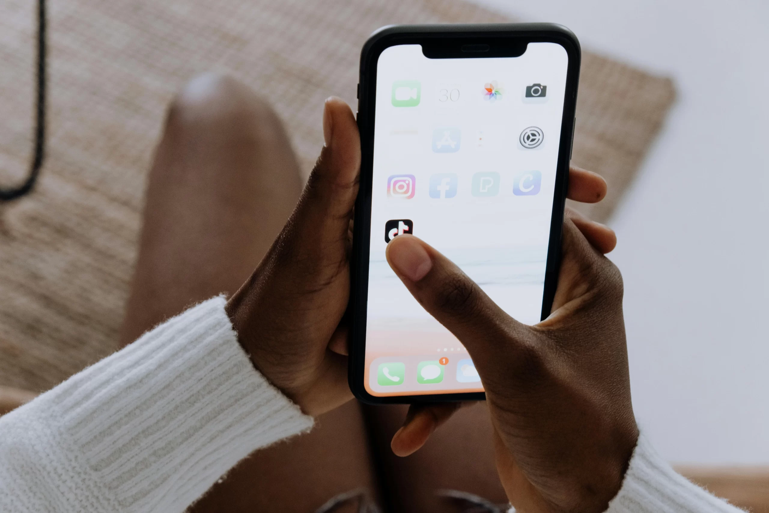 A man hands a smartphone using the TikTok app.