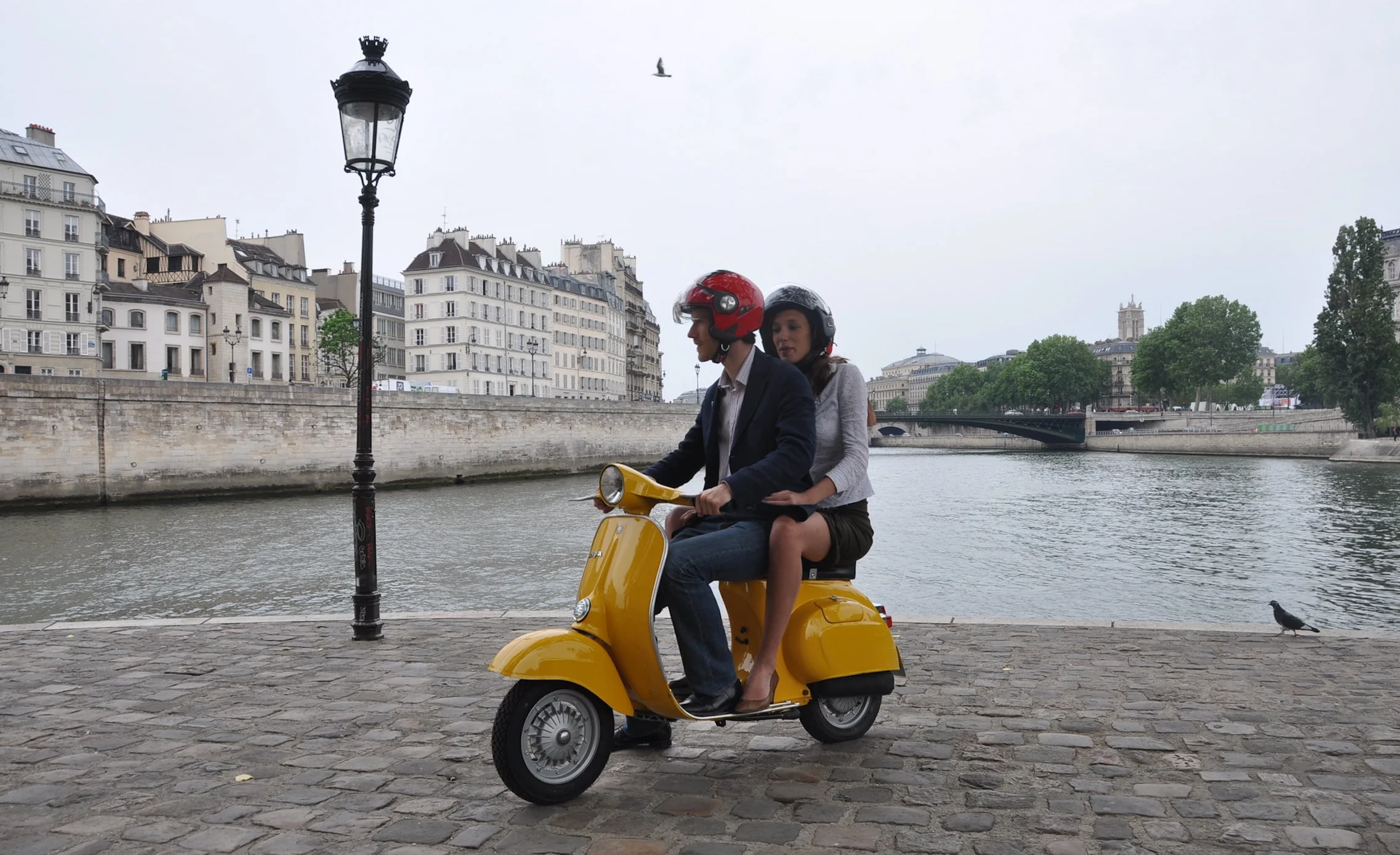 A couple on a vintage vespa.