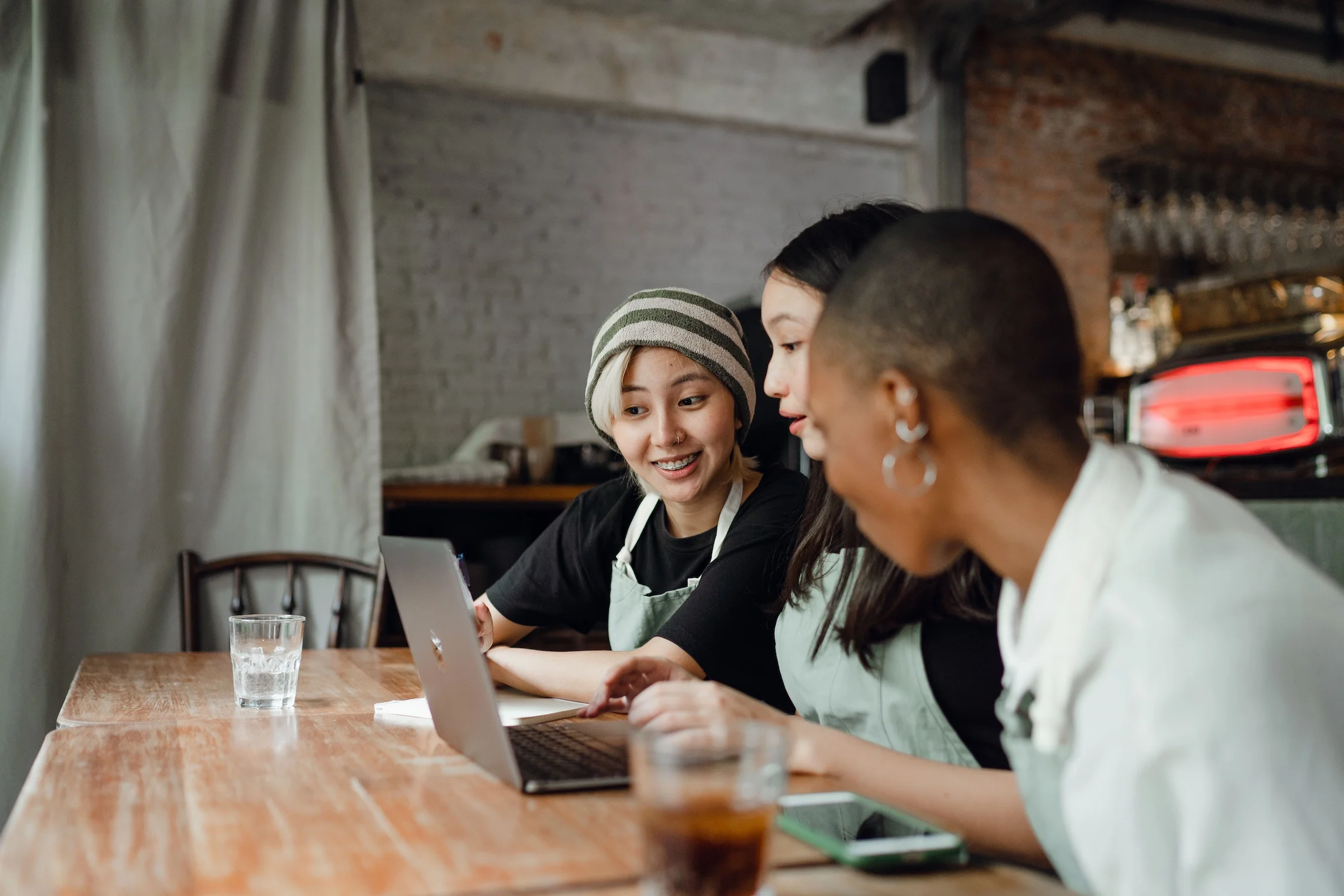 Three diverse women collaborating on a project.